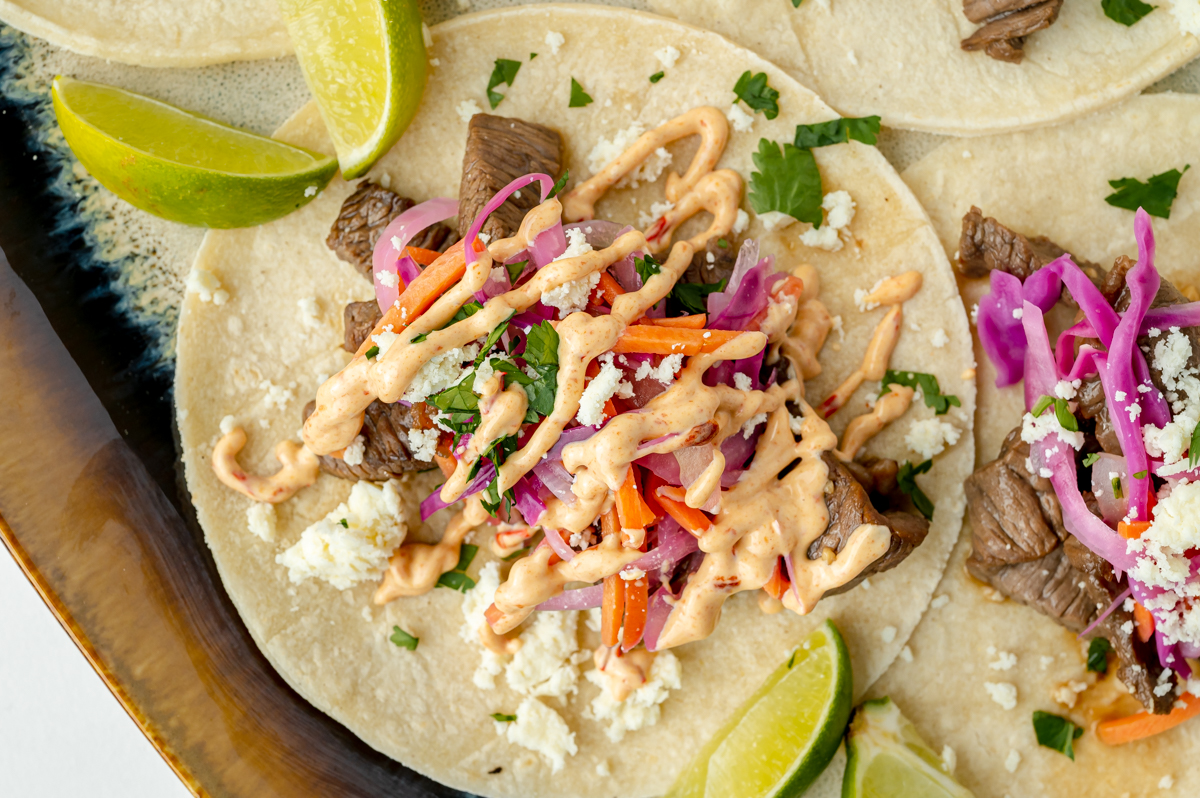 overhead shot of chipotle aioli drizzled onto korean taco