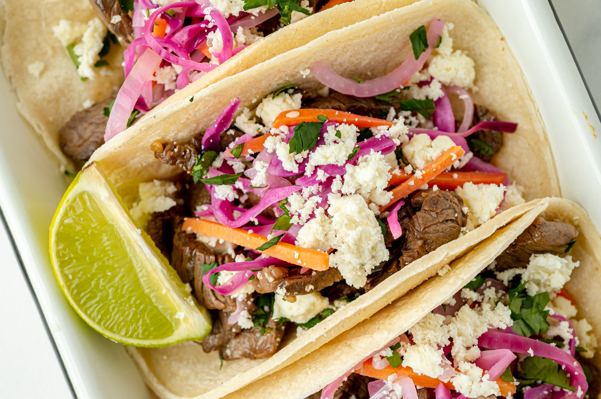 overhead shot of korean taco topped with cheese with lime wedge