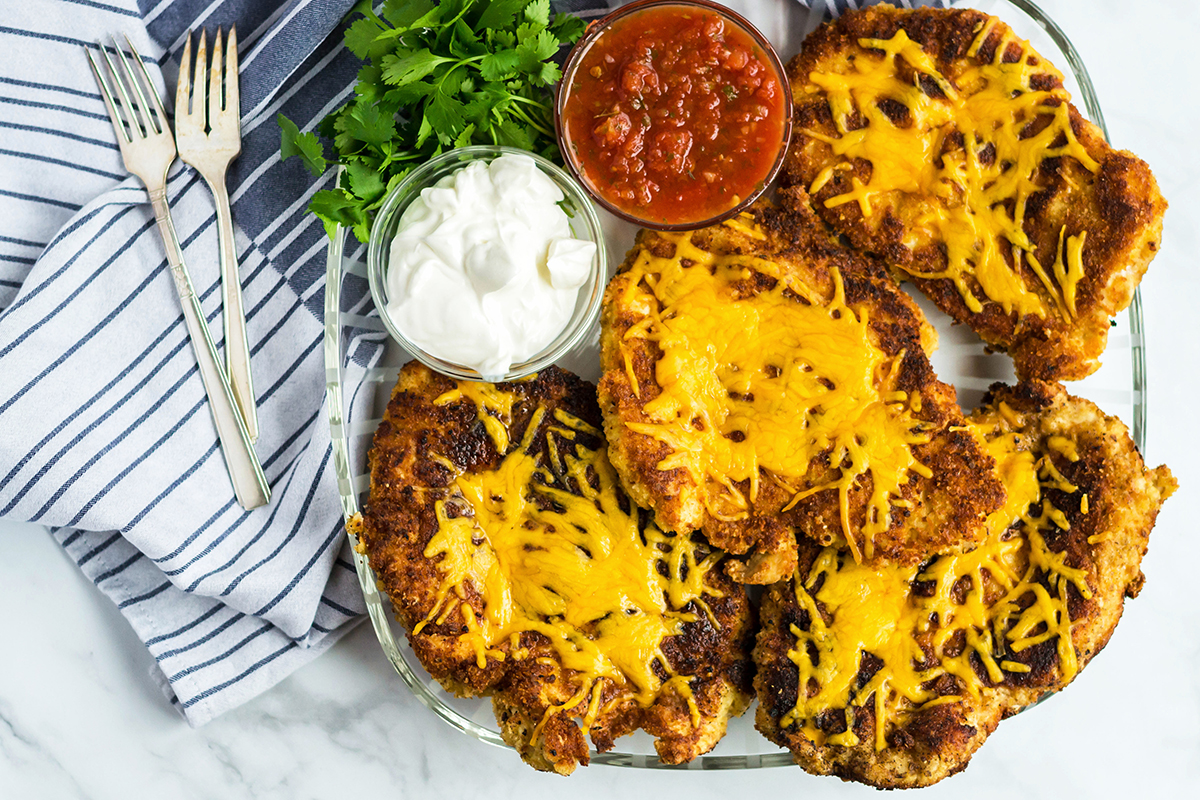 overhead shot of crispy mexican chicken topped with cheese on plate
