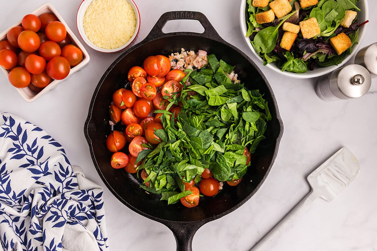 spinach, tomatoes and shallots in cast iron skillet