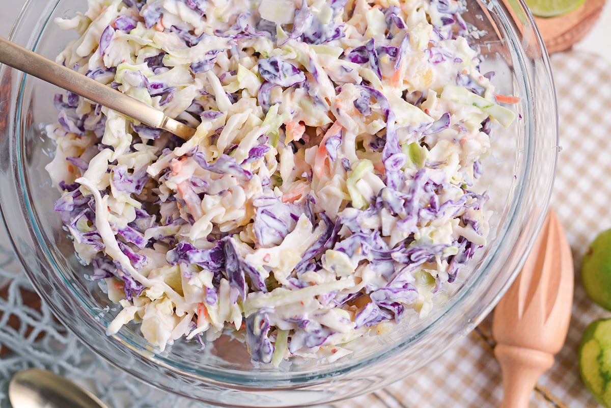 close up overhead shot of fork in bowl of yogurt pineapple coleslaw