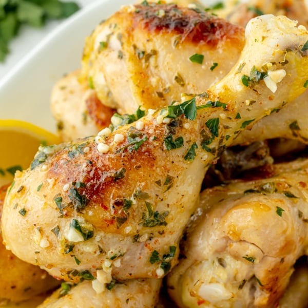 angled shot of platter of baked chicken drumsticks