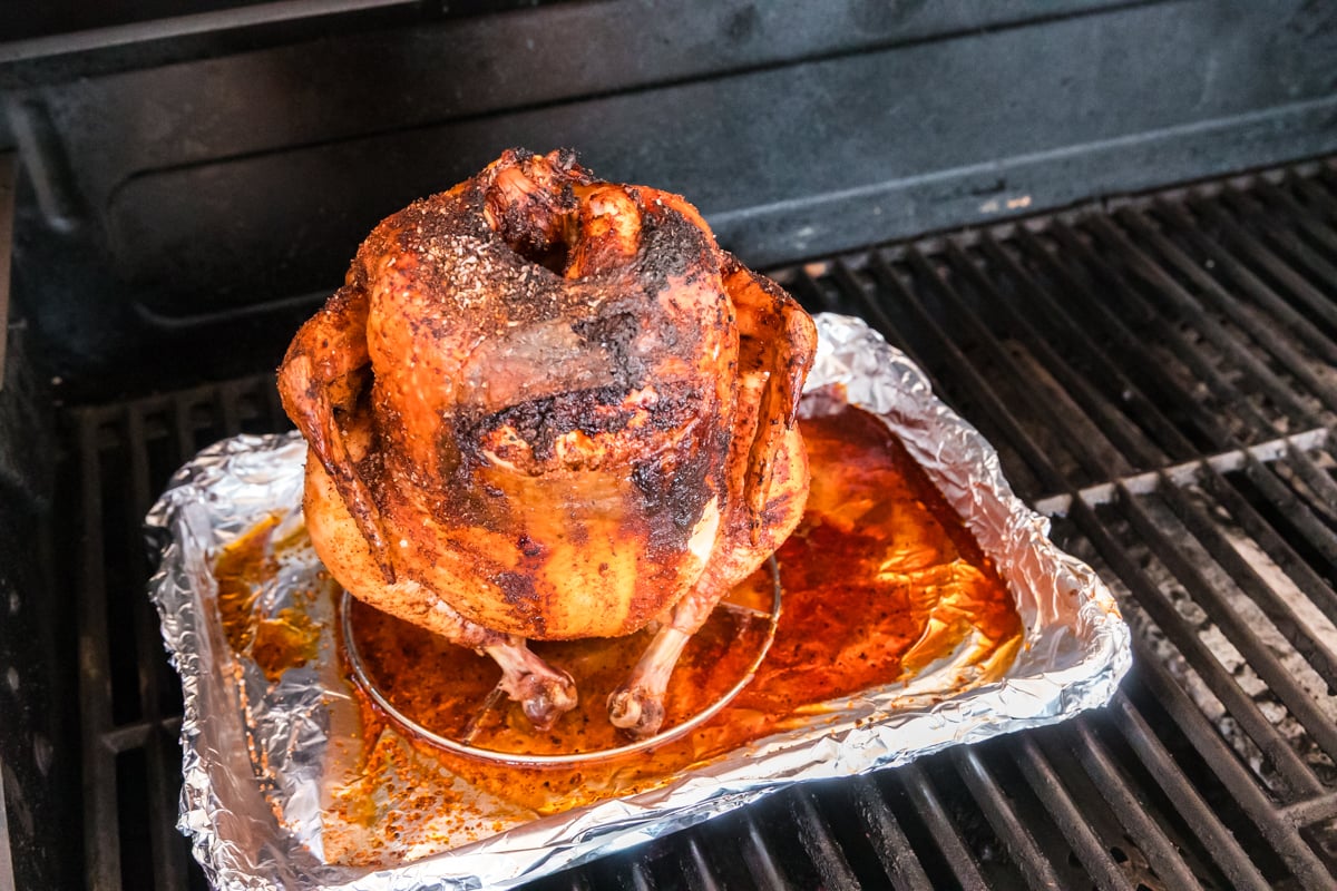 angled shot of beer can chicken cooking on grill