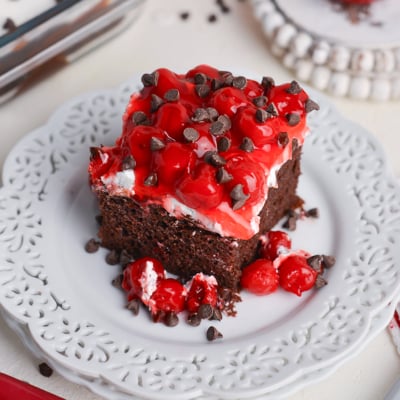 angled shot of slice of black forest poke cake on plate