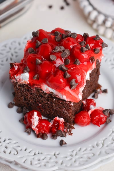angled shot of slice of black forest poke cake on plate