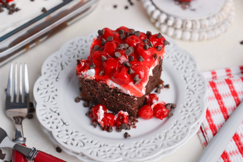 angled shot of slice of black forest poke cake on plate