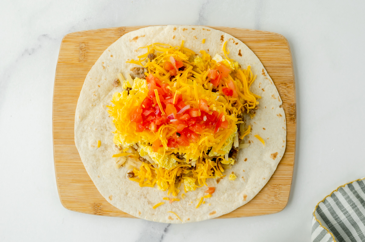 overhead shot of breakfast burrito toppings on tortilla