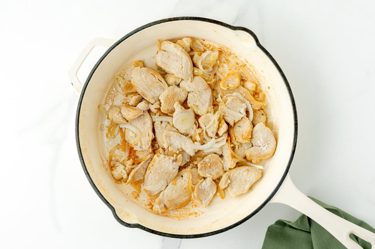 chicken and onions cooking in pan