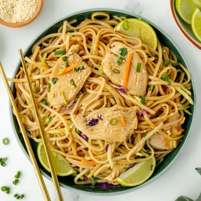overhead shot of bowl of chicken stir fry rice noodles with chopsticks