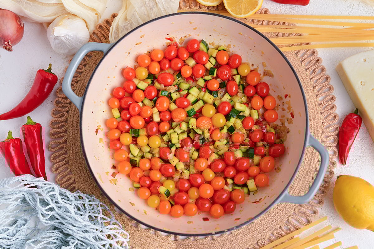 tomatoes and zucchini cooking in pot