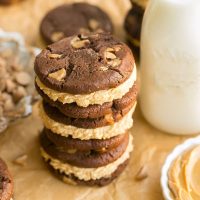 angled shot of stack of chocolate peanut butter cookie sandwiches with milk