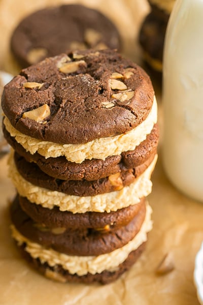 angled shot of stack of chocolate peanut butter cookie sandwiches with milk