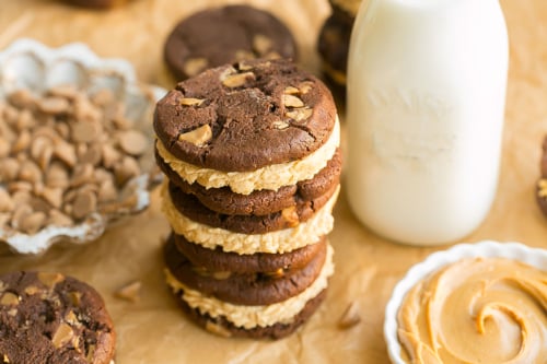 angled shot of stack of chocolate peanut butter cookie sandwiches with milk