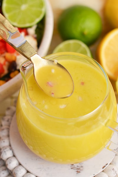 angled shot of spoon in jar of citrus salad dressing
