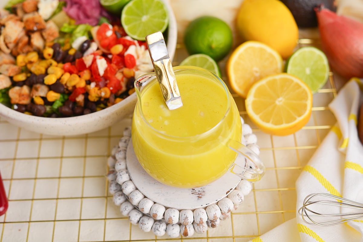 angled shot of spoon in jar of citrus vinaigrette