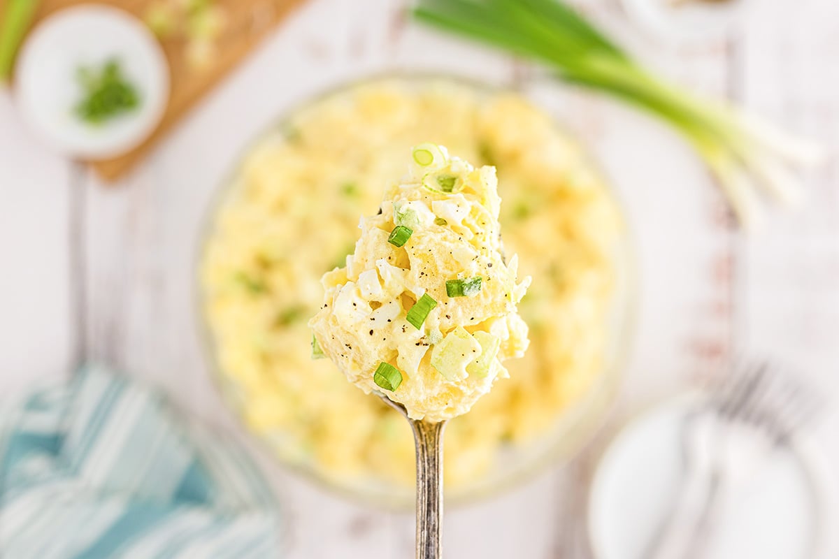 close up of classic potato salad on a spoon