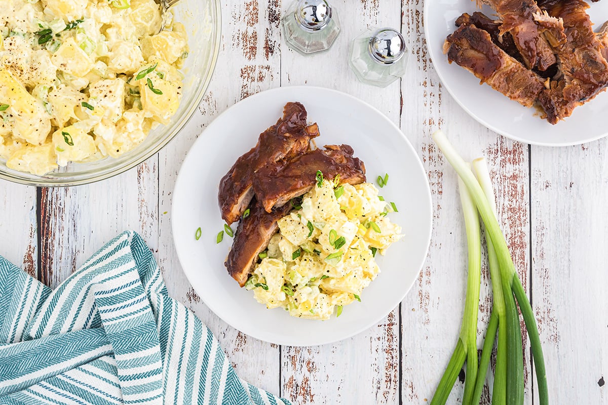 overhead shot of classic potato salad on plate with ribs