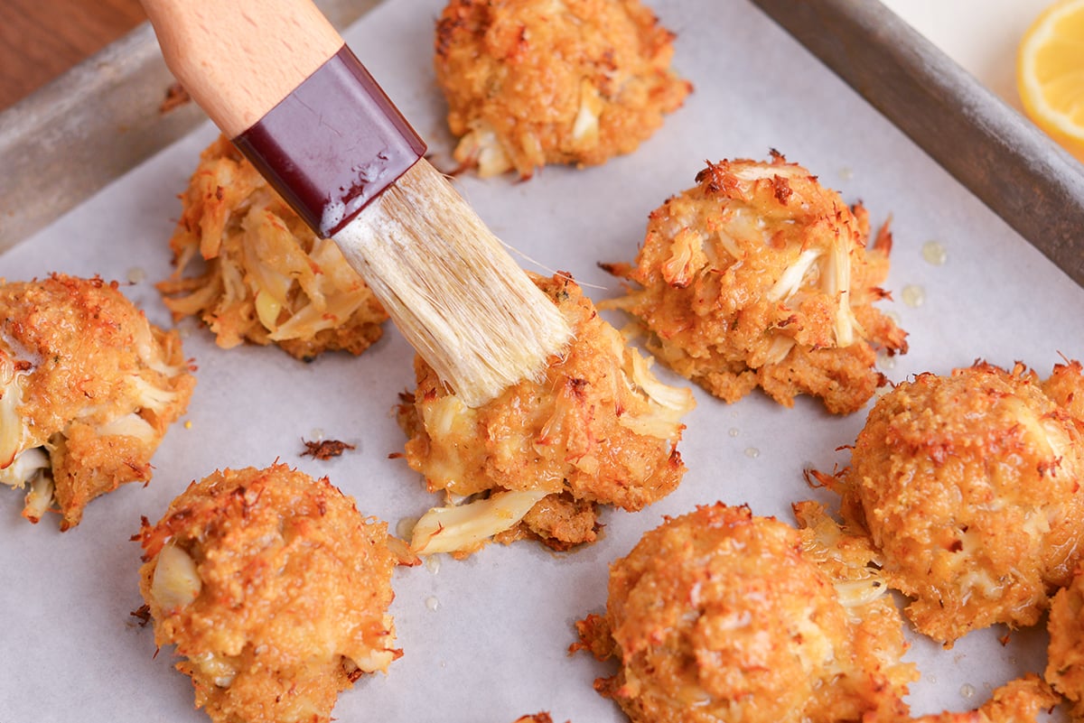 angled shot of melted butter brushed onto crab balls