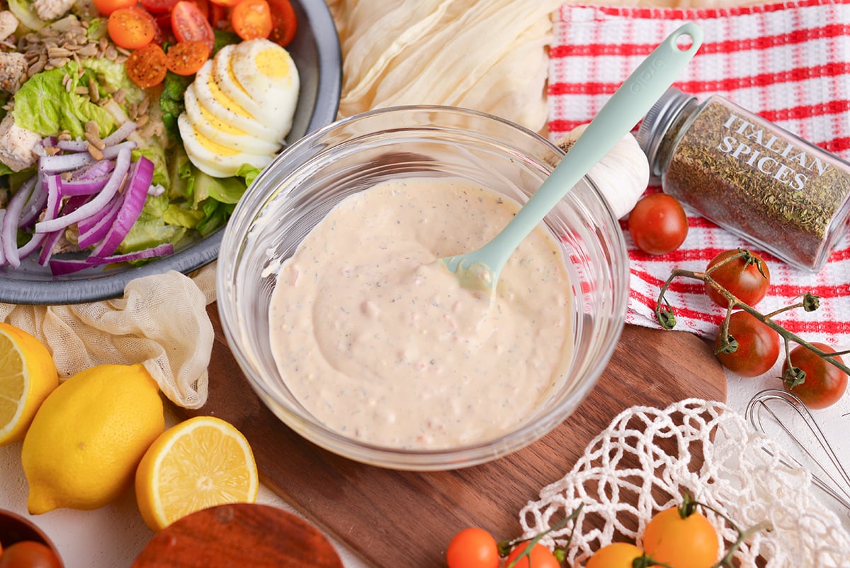 angled shot of spatula in bowl of creamy italian dressing