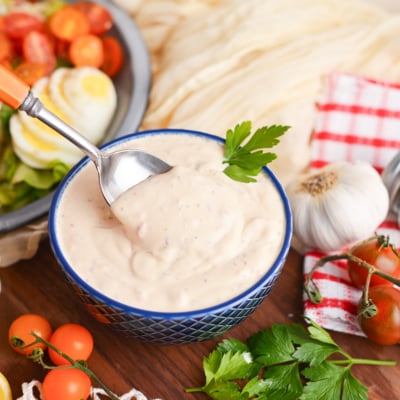 angled shot of spoon in bowl of creamy italian dressing