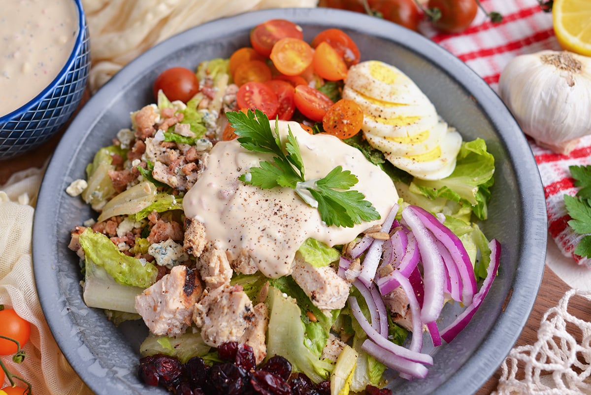 angled shot of salad topped with creamy dressing