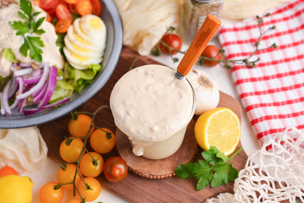 angled shot of spoon in jar of creamy italian dressing