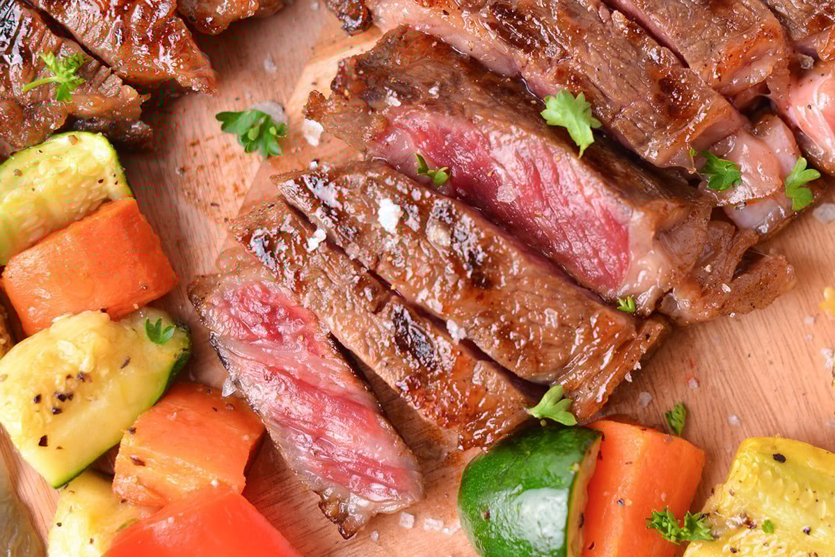 close up overhead shot of sliced denver steak with veggies