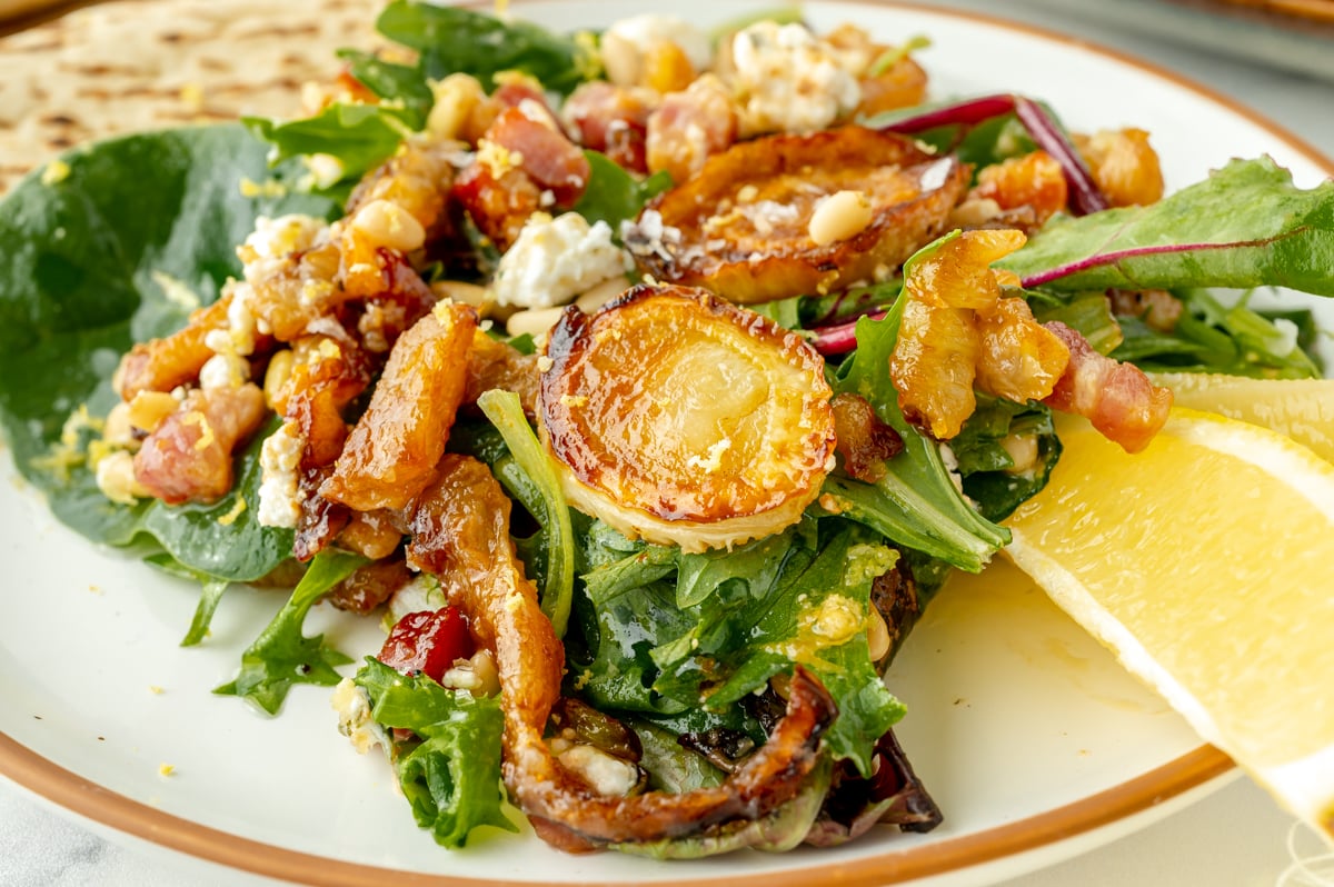 angled shot of fennel salad on plate with lemon wedges
