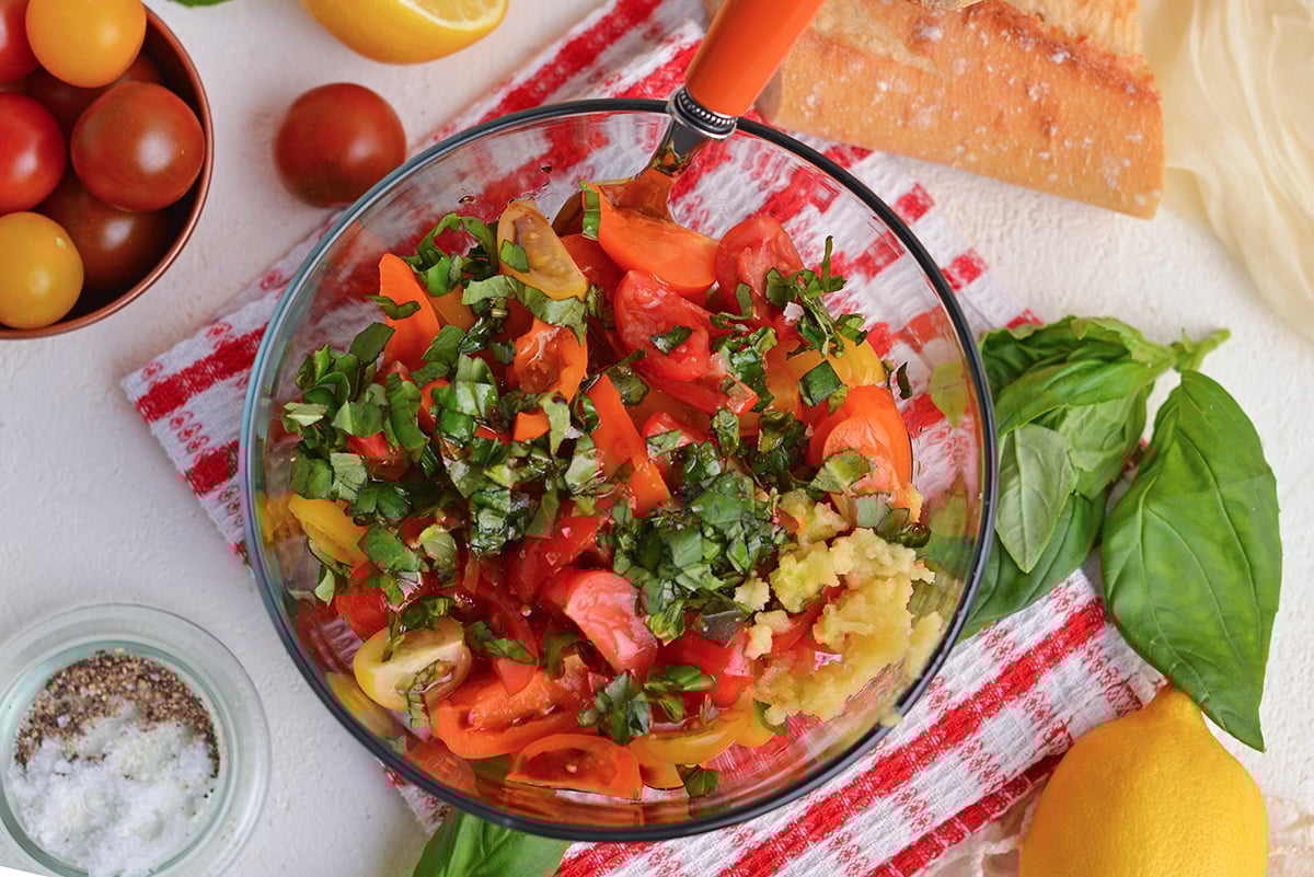 overhead shot of tomatoes, basil and garlic in bowl
