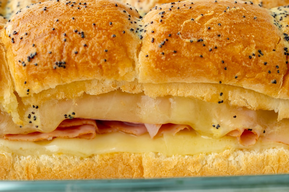 close up side shot of ham and cheese sliders