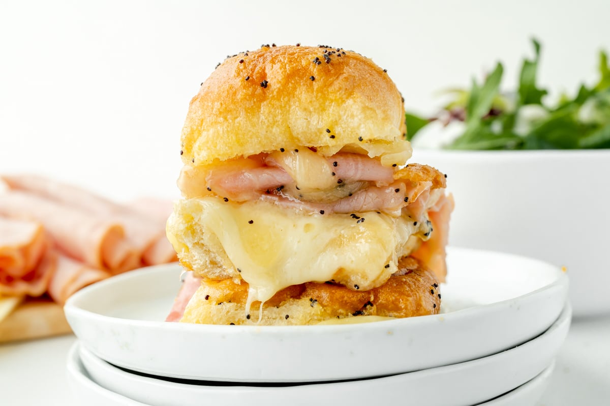 straight on shot of stack of ham and cheese sliders on plate