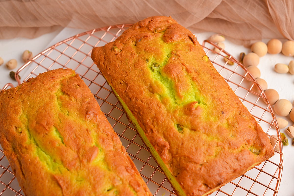 angled shot of baked pistachio bred loaves on cooling rack