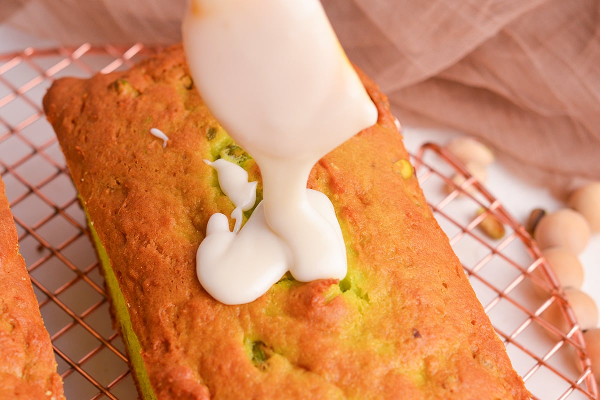 close up shot of glaze added to pistachio bread
