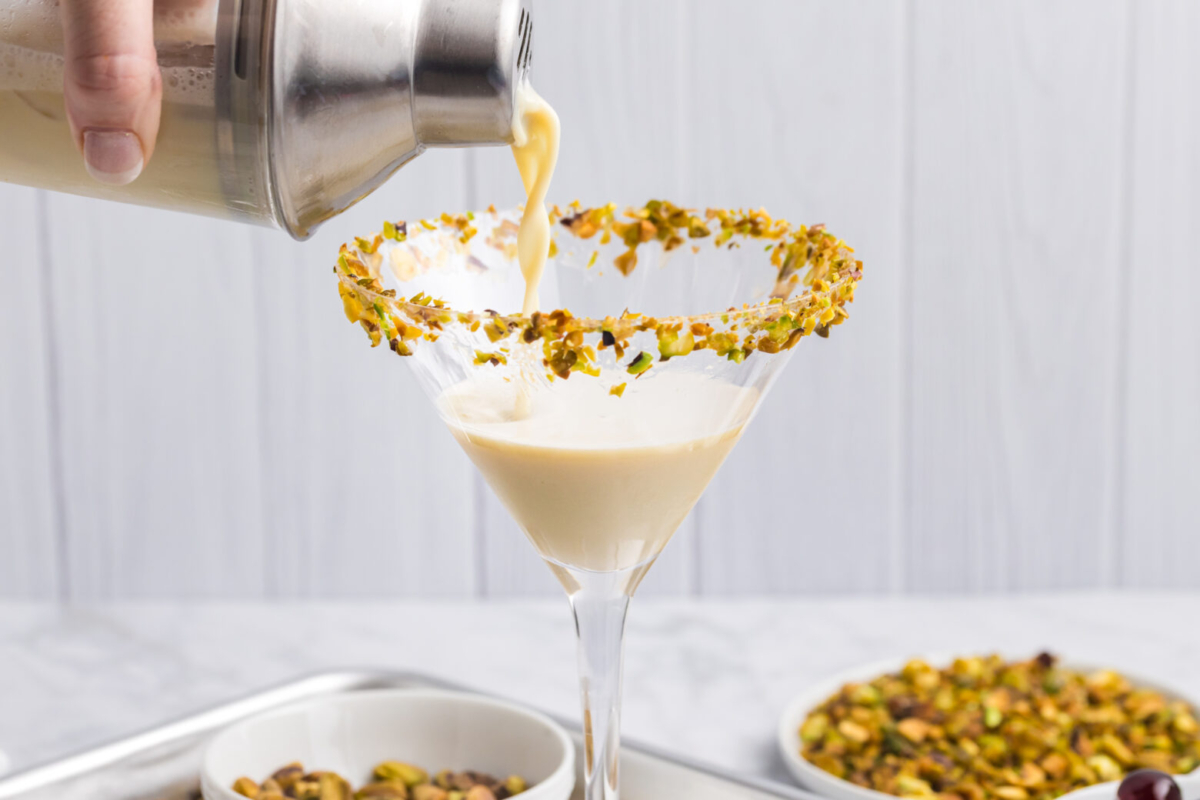 shaker pouring martini into martini glass