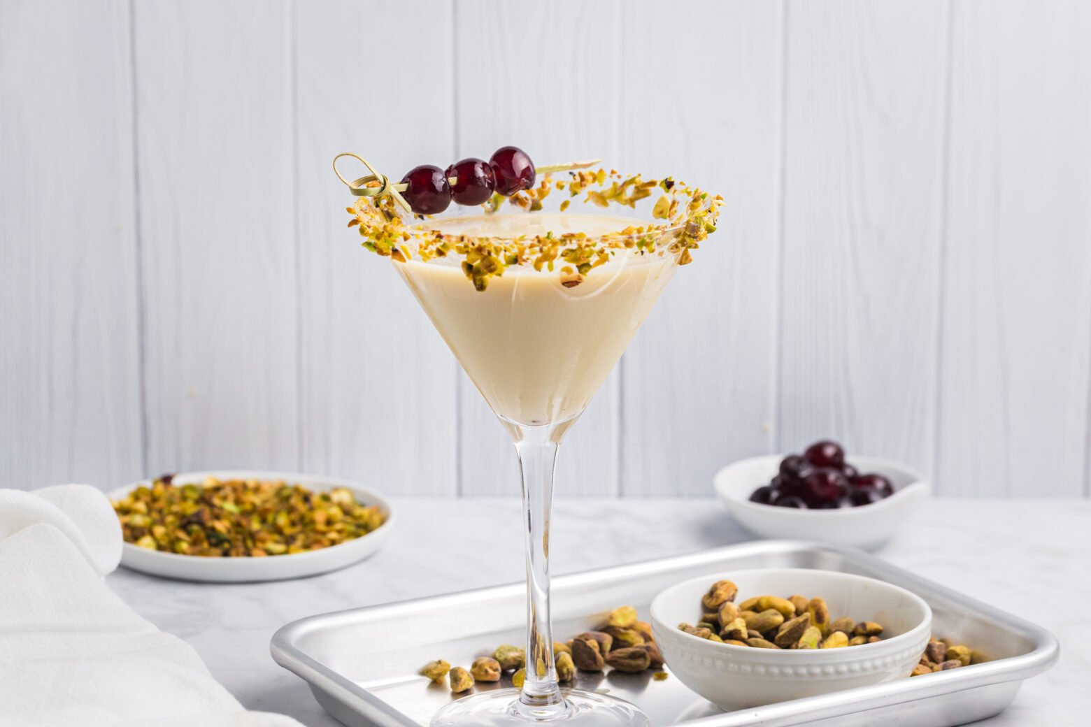 pistachio martini on tray with three cherries as garnish