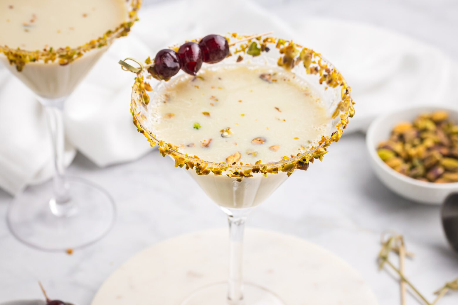 angled shot of pistachio martini with cherry garnish