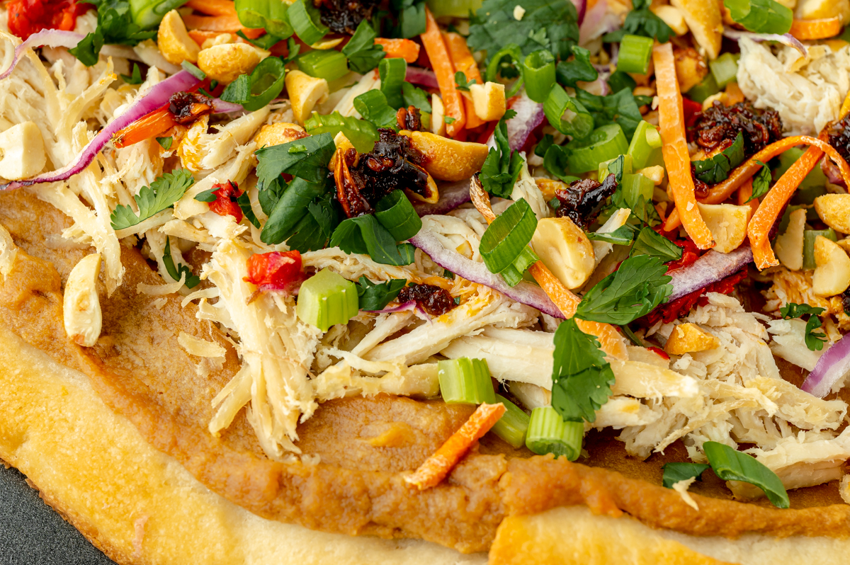 close up angled shot of thai chicken pizza