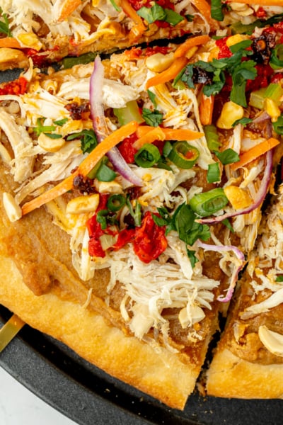 close up overhead shot of slice of thai chicken pizza