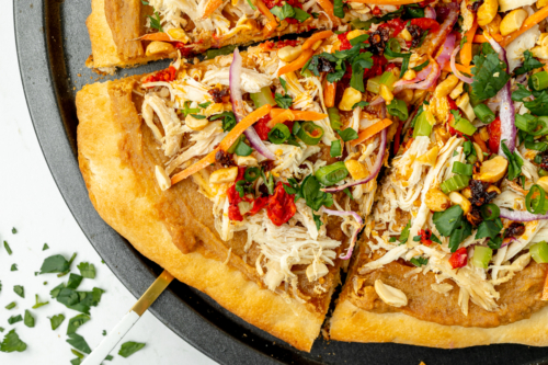 close up overhead shot of slice of thai chicken pizza