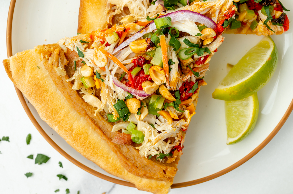 close up overhead shot of slice of pizza on plate with limes