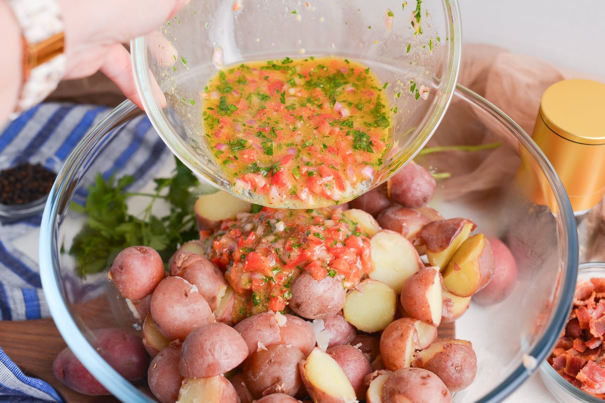 dressing poured over bowl of potatoes