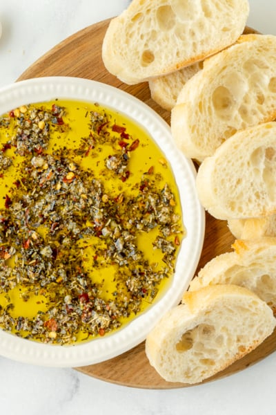 overhead shot of olive oil bread dip on board with bread slices