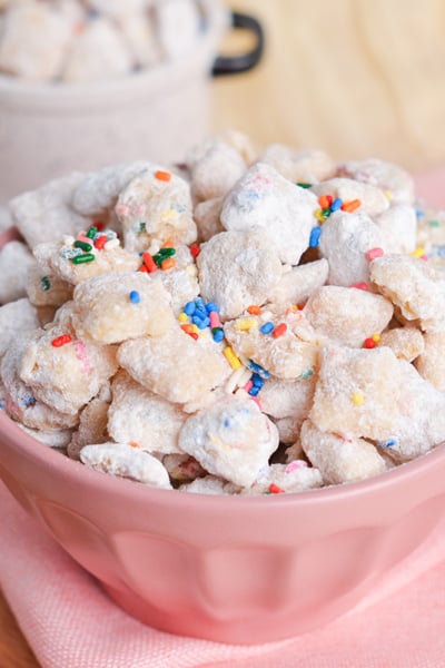 angled shot of pink bowl of cake batter puppy chow