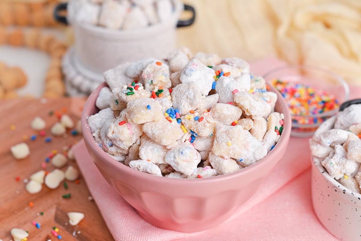 angled shot of pink bowl of cake batter puppy chow