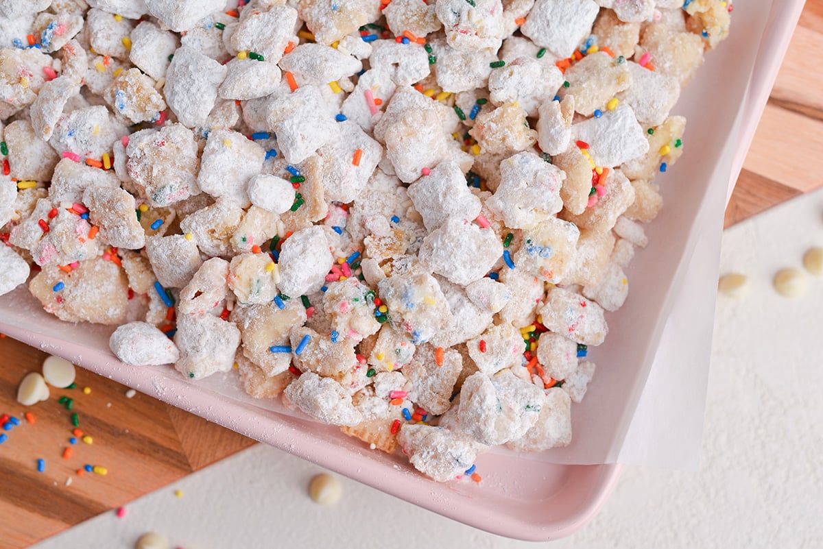 overhead shot of corner of baking sheet with birthday cake puppy chow