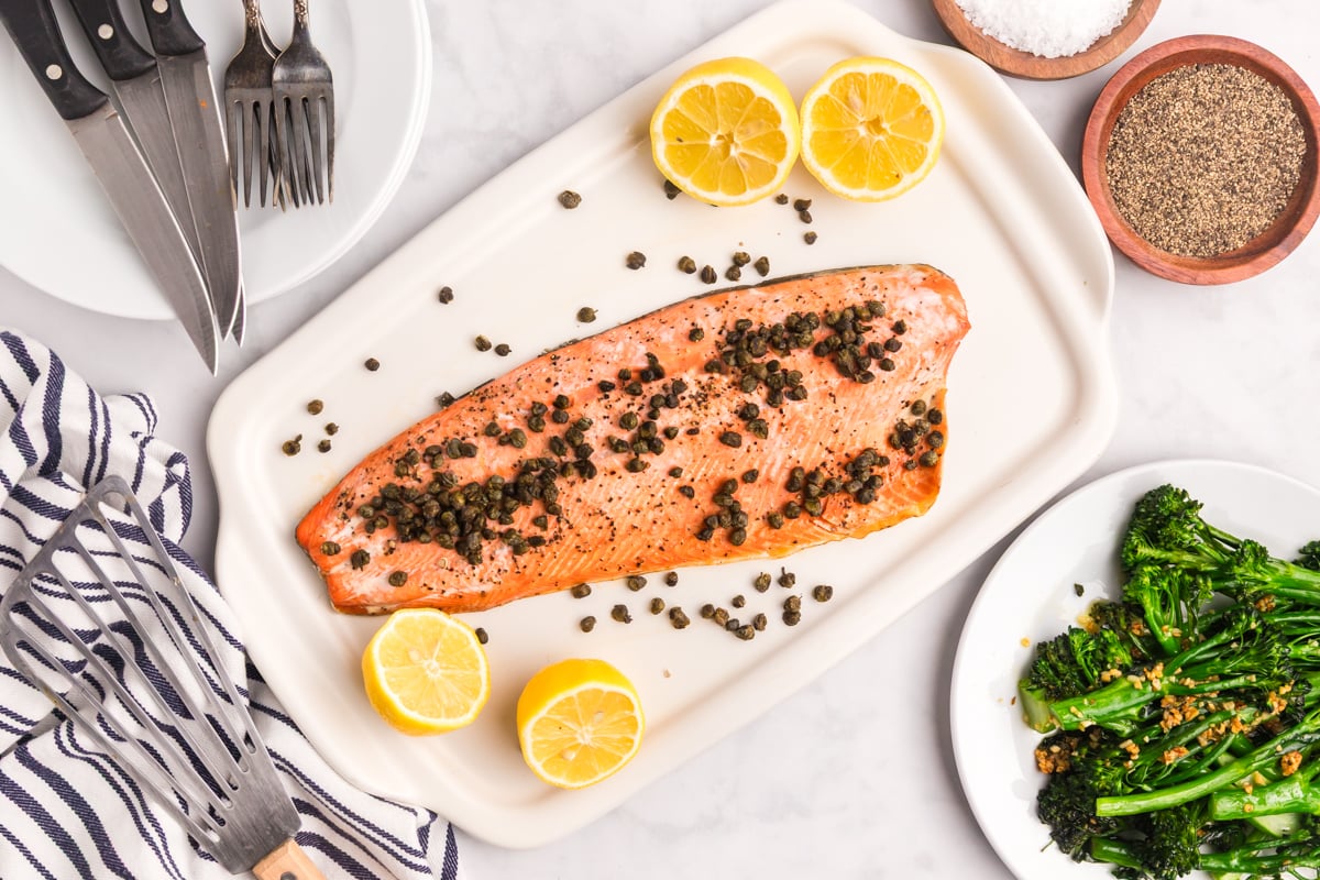 overhead shot of crispy caper lemon salmon on tray with lemons