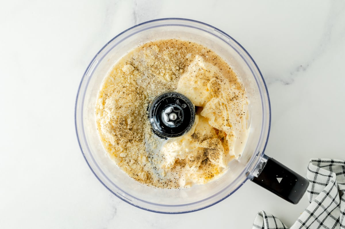 overhead shot of parmesan peppercorn salad dressing ingredients in food processor