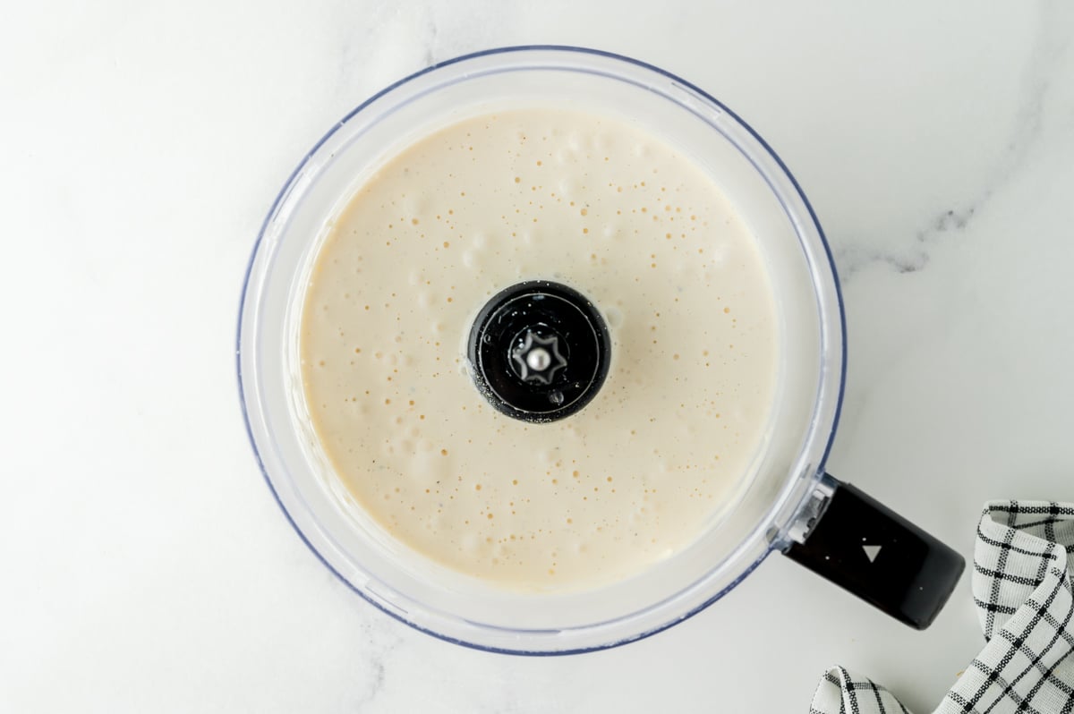overhead shot of creamy dressing in food processor