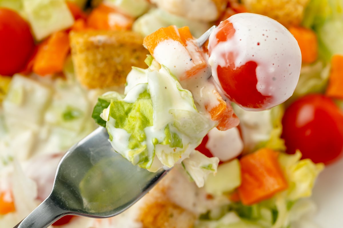 bite of dressing coated salad on fork
