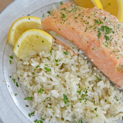 Ranch rice on a plate with lemons and salmon